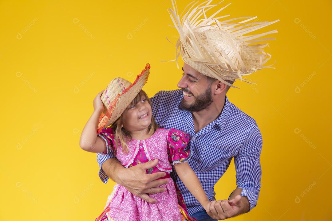 Pai e filha vestidos com roupas de festa junina. Papai jovem um