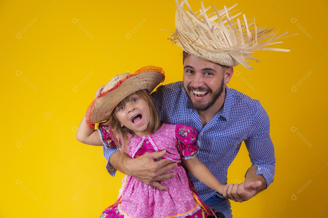 Pai e filha vestidos com roupas de festa junina. Papai jovem um