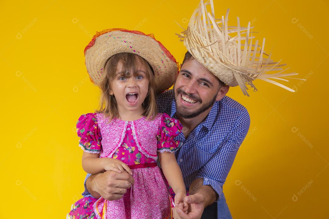 Pai e filha vestidos com roupas de festa junina. Papai jovem um