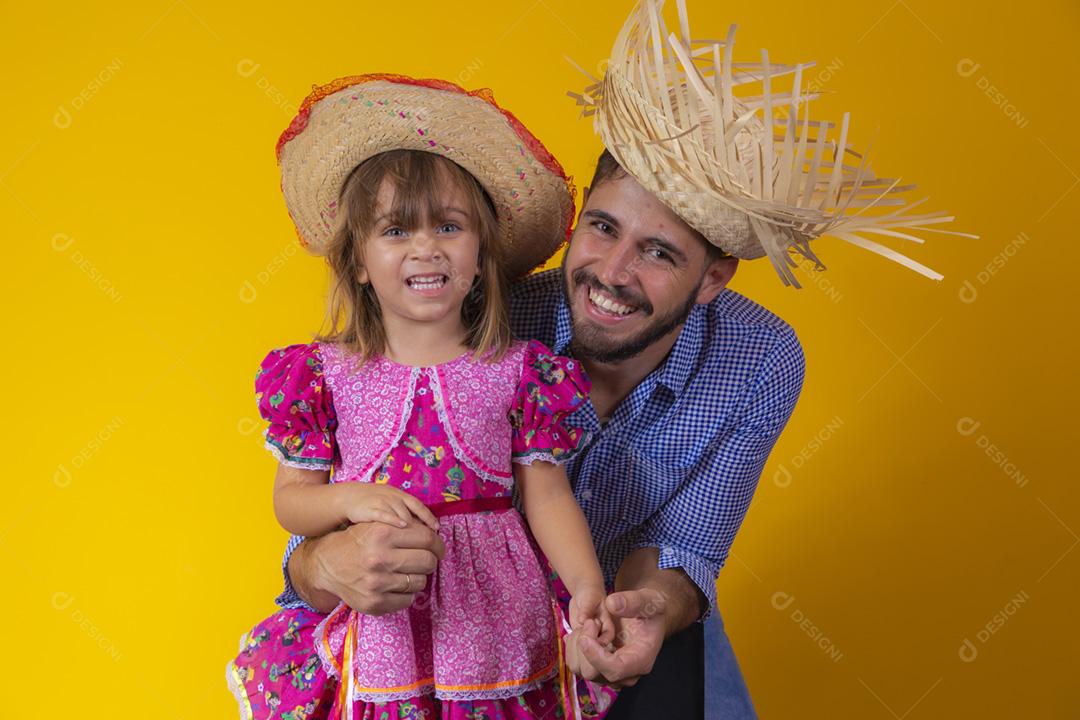 Pai e filha vestidos com roupas de festa junina. Papai jovem um