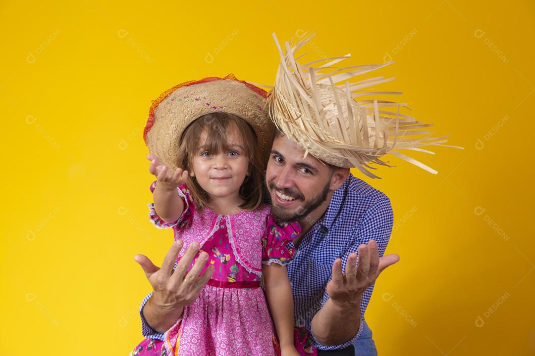 Pai e filha vestidos com roupas de festa junina. Papai jovem um