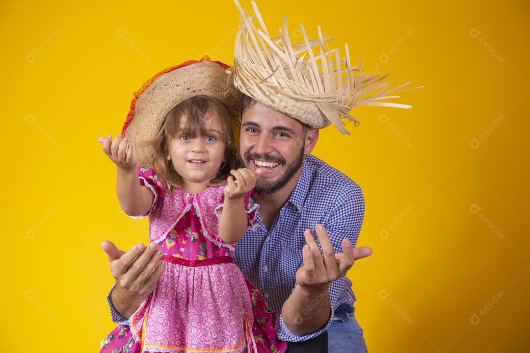 Pai e filha vestidos com roupas de festa junina. Papai jovem um