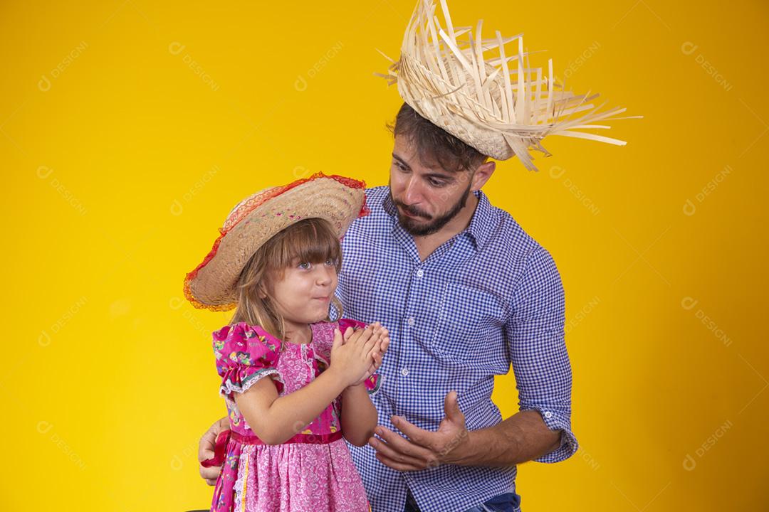 Pai e filha vestidos com roupas de festa junina. Papai jovem um