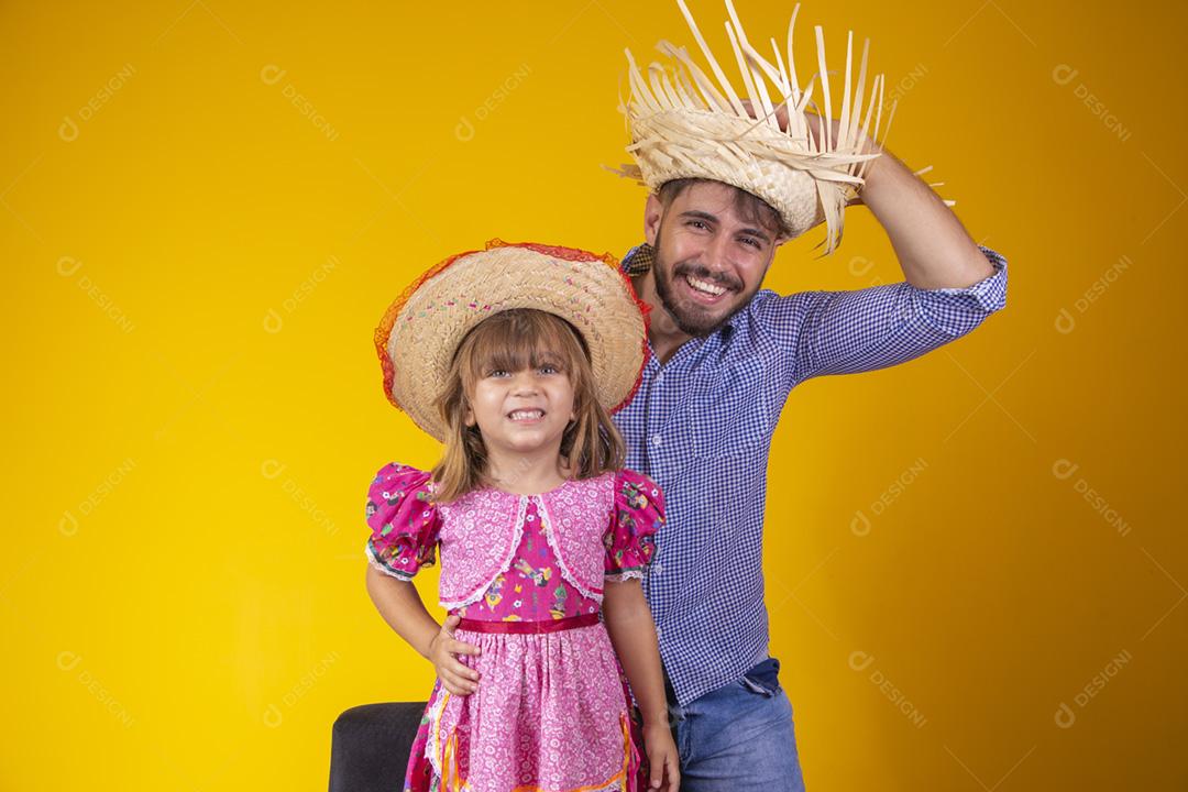 Pai e filha vestidos com roupas de festa junina. Papai jovem um