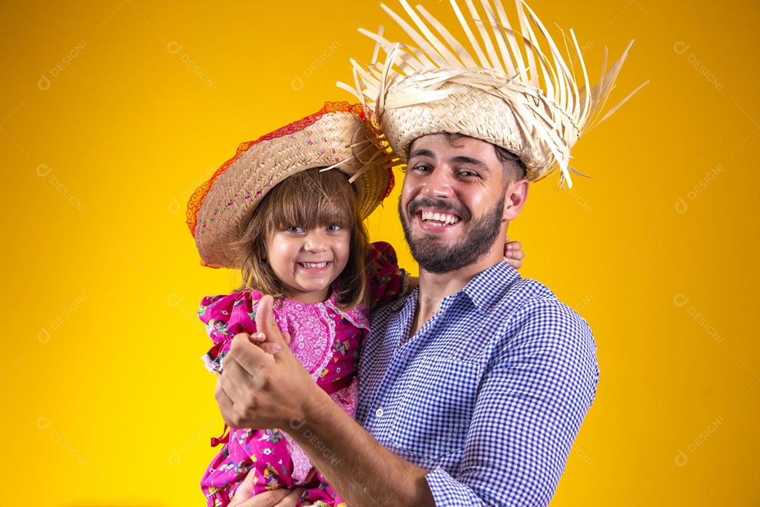 Pai e filha vestidos com roupas de festa junina. Papai jovem um