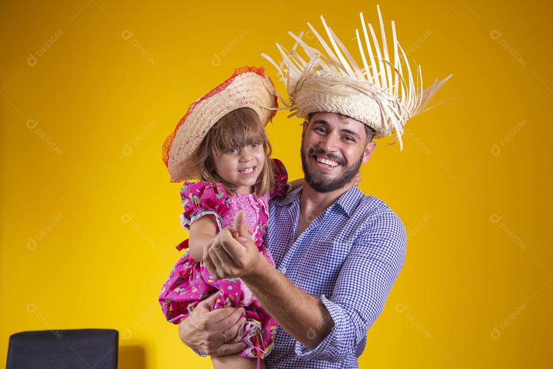 Pai e filha vestidos com roupas de festa junina. Papai jovem um