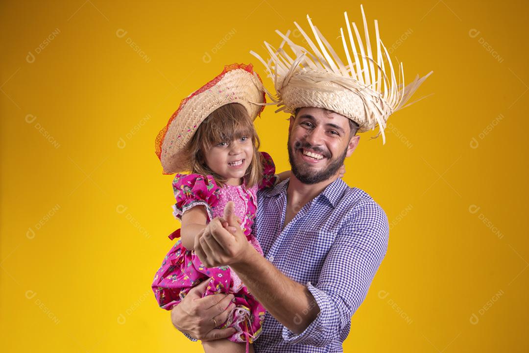 Pai e filha vestidos com roupas de festa junina. Papai jovem um