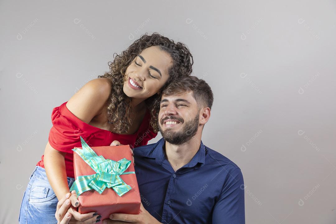 Lindo casal jovem. A mulher romântica entrega um presente de época natalícia t