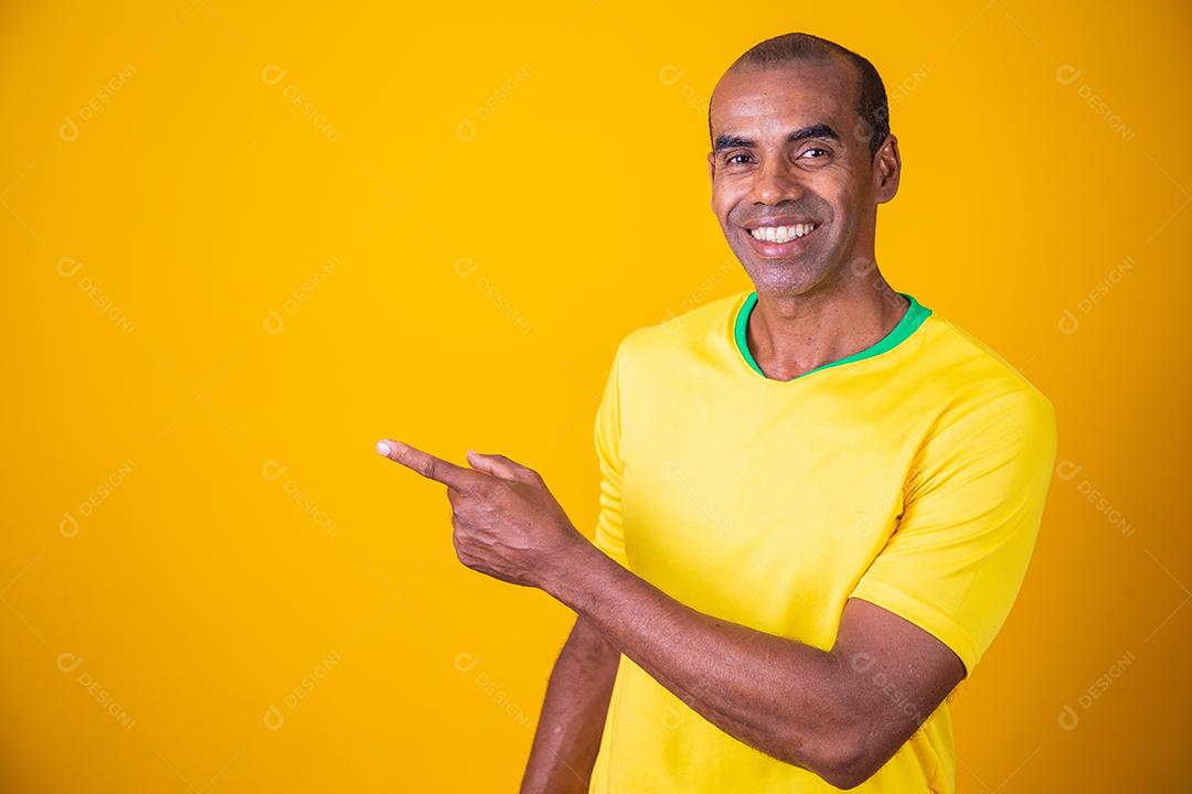 bonito homem afro brasileiro apontando para o lado no espaço livre