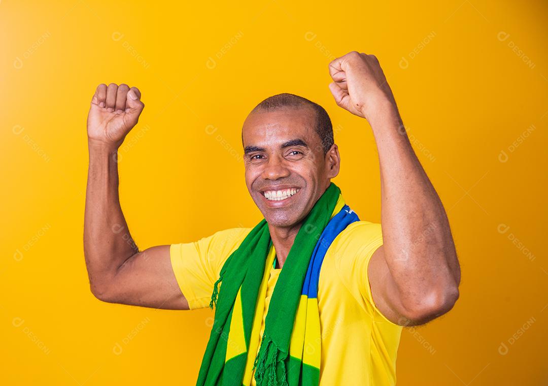 Jogador de futebol brasileiro, comemorando em um fundo amarelo.