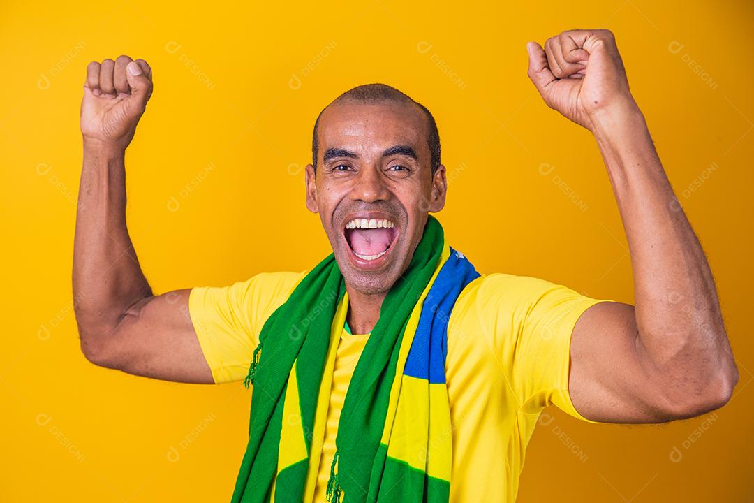 Jogador de futebol brasileiro, comemorando em um fundo amarelo.