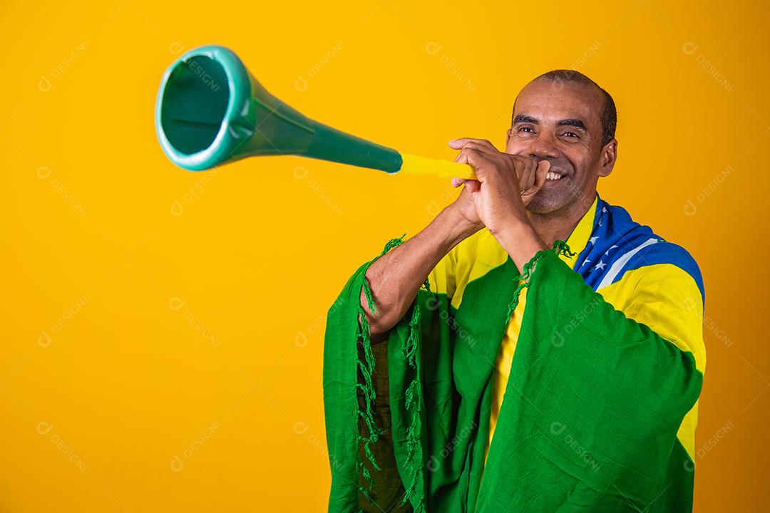 fã brasileiro comemorando em fundo amarelo