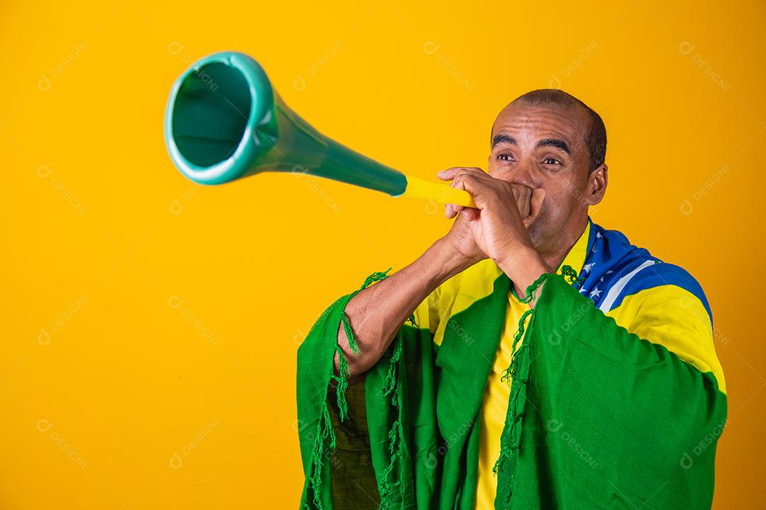 fã brasileiro comemorando em fundo amarelo