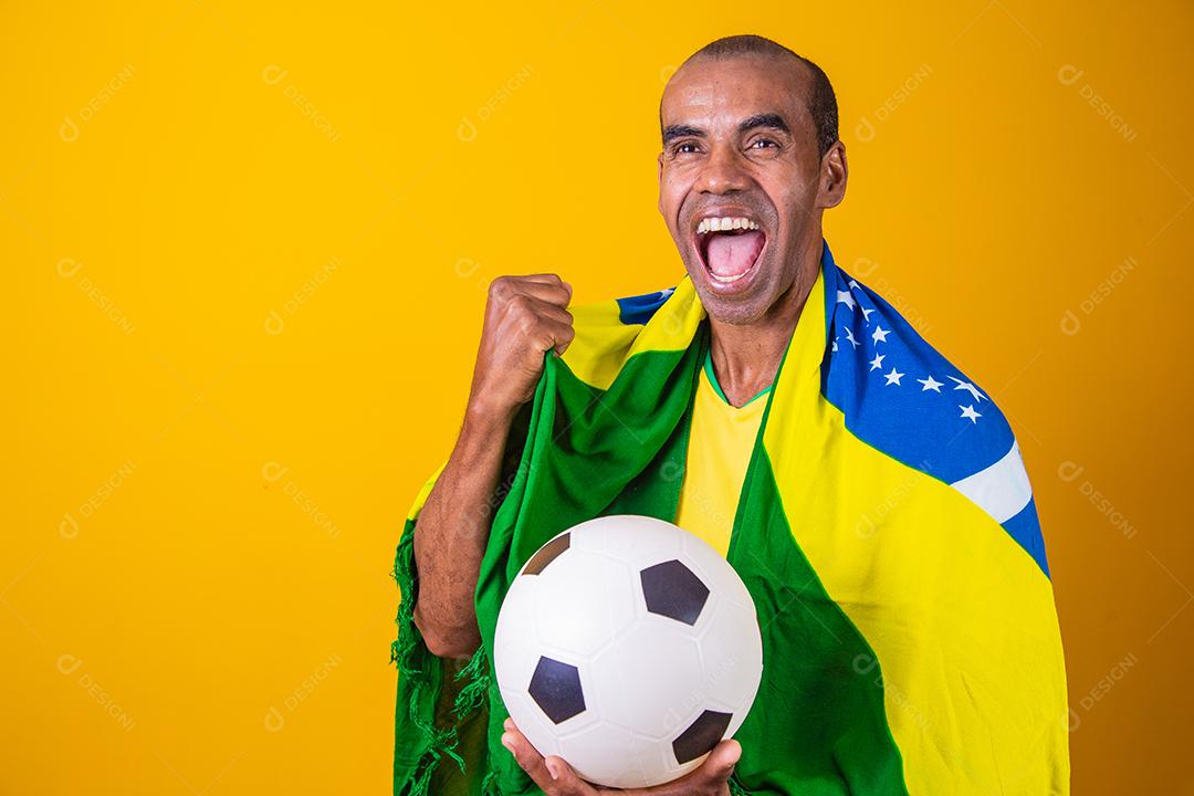 fã brasileiro comemorando em fundo amarelo