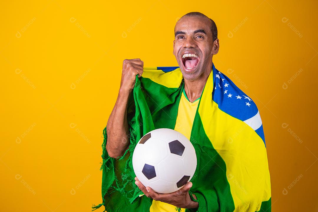 fã brasileiro comemorando em fundo amarelo