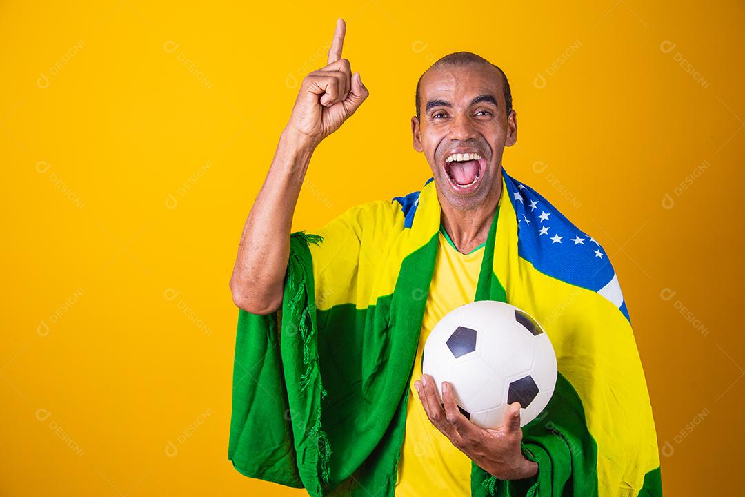 fã brasileiro comemorando em fundo amarelo