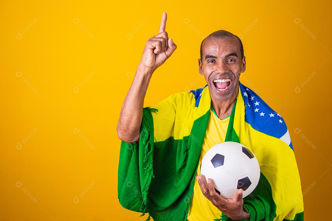 fã brasileiro comemorando em fundo amarelo