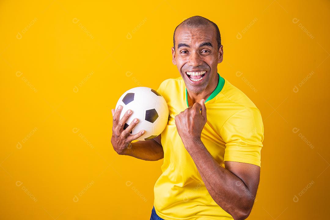 fã brasileiro comemorando em fundo amarelo