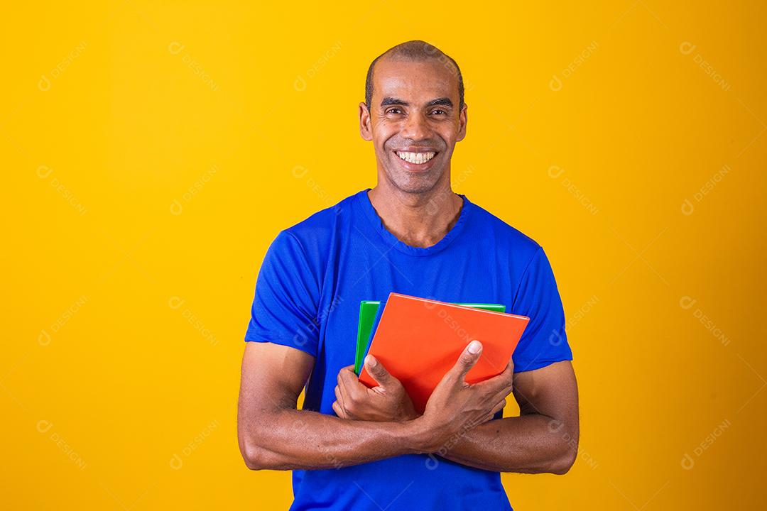 Homem estudante maduro sorrindo olhando para a câmera em fundo amarelo. homem estudante negro maduro