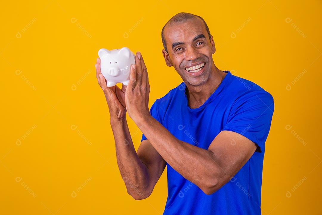 Afro man holding a piggy bank