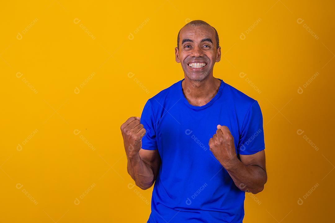 Bonito e atraente homem alegre e alegre, mostrando um gesto legal vencedor, comemorando