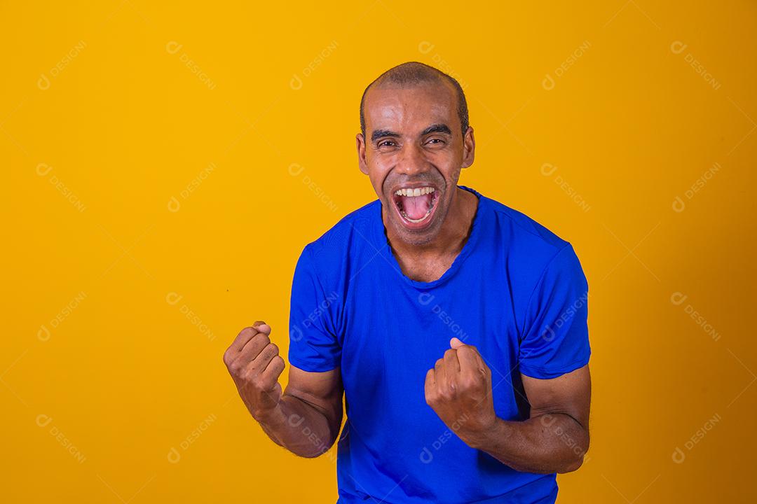 Bonito e atraente homem alegre e alegre, mostrando um gesto legal vencedor, comemorando