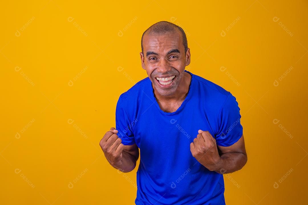 Bonito e atraente homem alegre e alegre, mostrando um gesto legal vencedor, comemorando