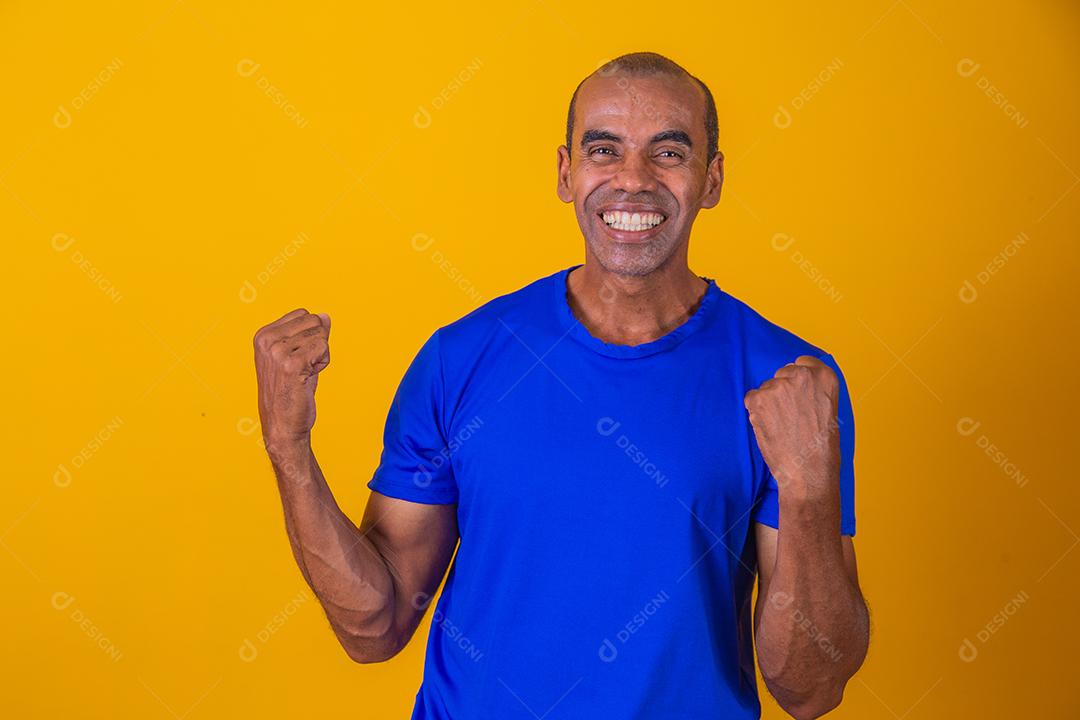 Bonito e atraente homem alegre e alegre, mostrando um gesto legal vencedor, comemorando