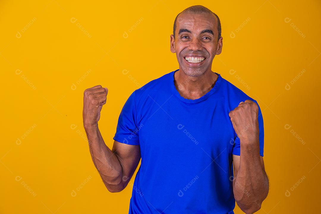 Bonito e atraente homem alegre e alegre, mostrando um gesto legal vencedor, comemorando