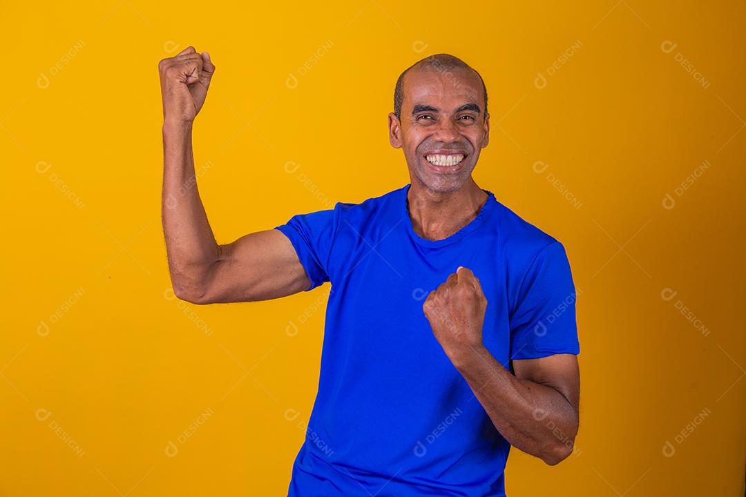 Bonito e atraente homem alegre e alegre, mostrando um gesto legal vencedor, comemorando