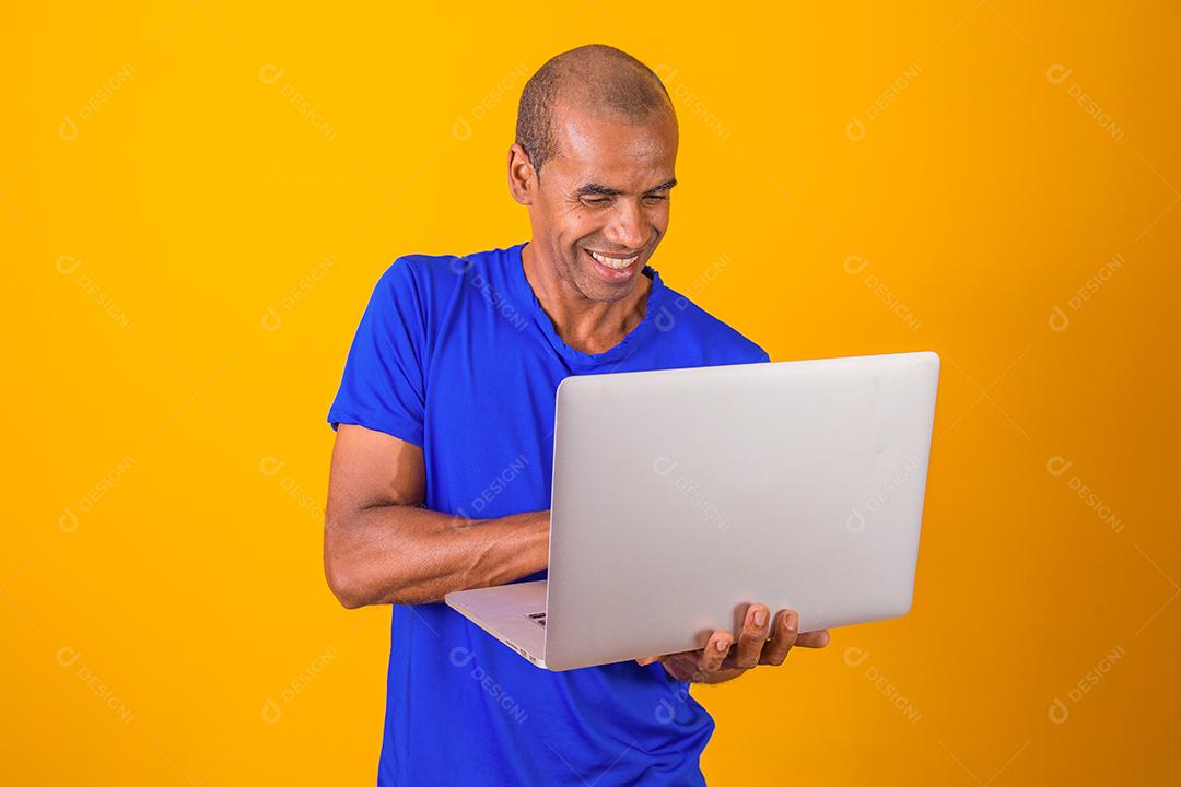 Homem afro fazendo compras ou trabalhando online pelo computador.