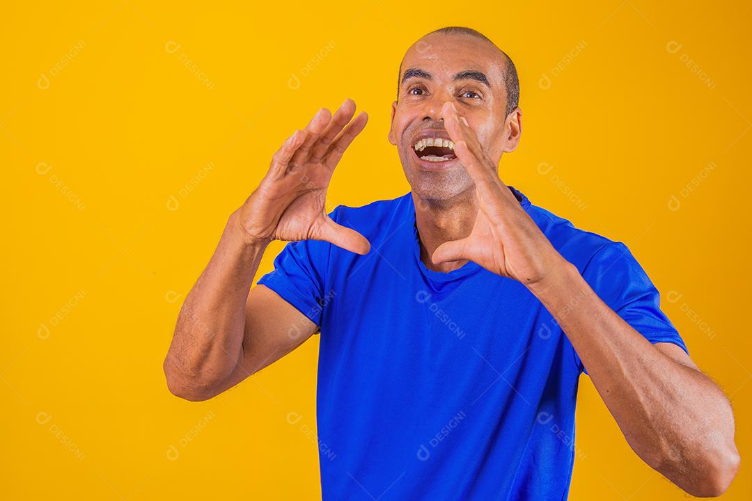 Homem gritando com as mãos na boca