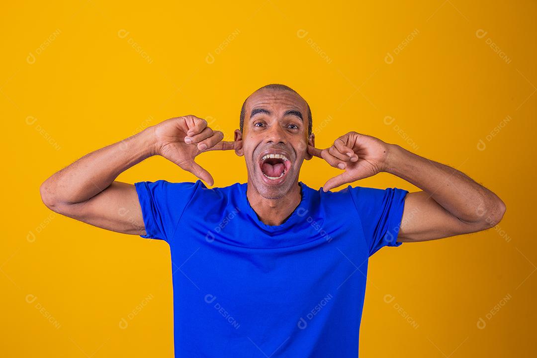 Retrato de homem afro-americano furioso cobrindo os ouvidos e gritando