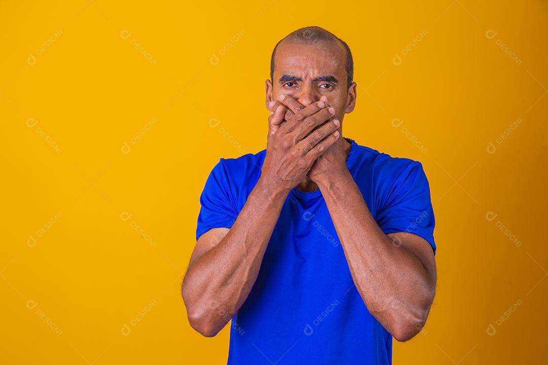homem negro com a mão na boca em silêncio. Conceito de racismo e opressão