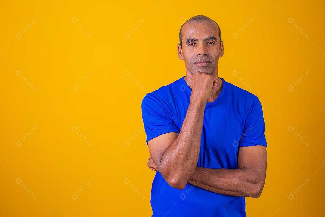 Homem afro mais velho sorrindo olhando para a câmera no fundo amarelo