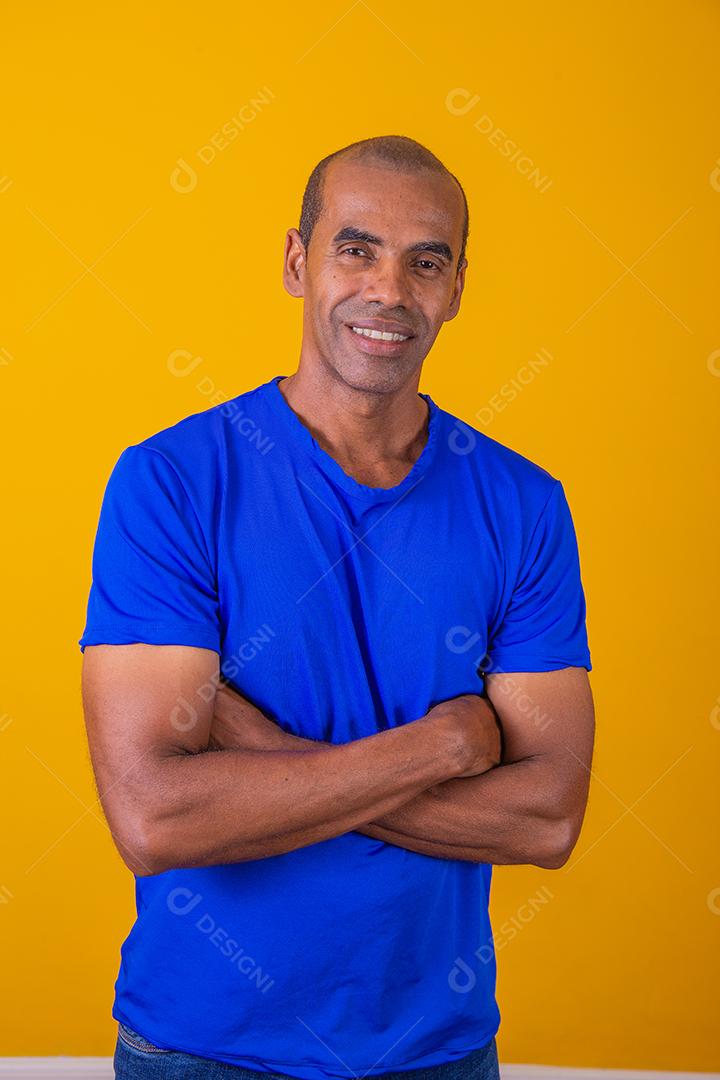 Homem negro mais velho cruzando os braços com confiança. otimista, feliz