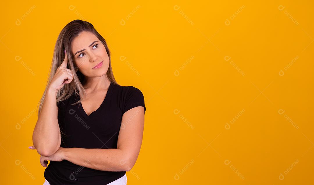 mulher loira pensativa em fundo amarelo