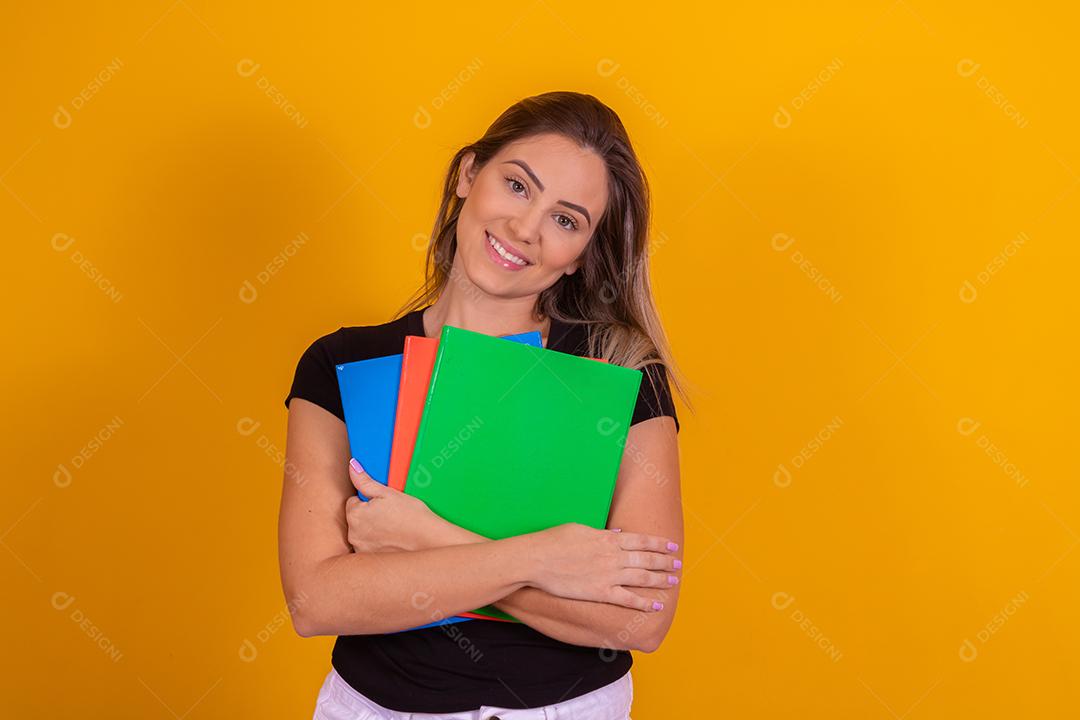 Aluna jovem com livros de volta para a escola sobre fundo amarelo