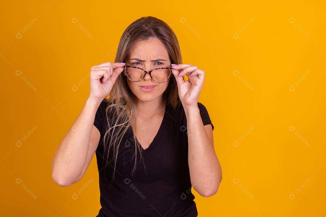 Mulher loira usando oculos, blusa preta fazendo gestos com as mãos