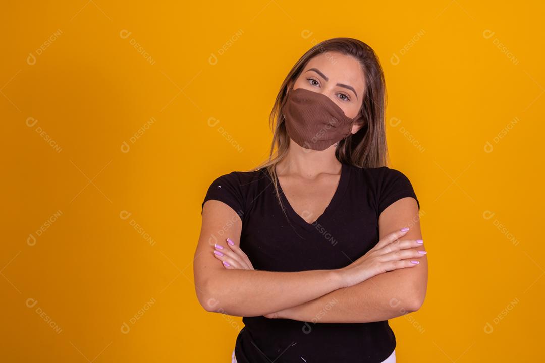 Mulher loira usando mascara, blusa preta fazendo gestos com as mãos