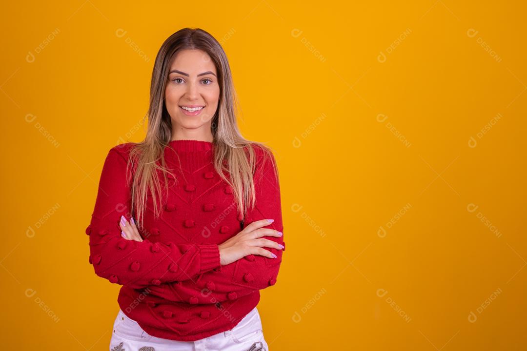 Mulher loira com um chapeu de papai noel em fundo amarelo