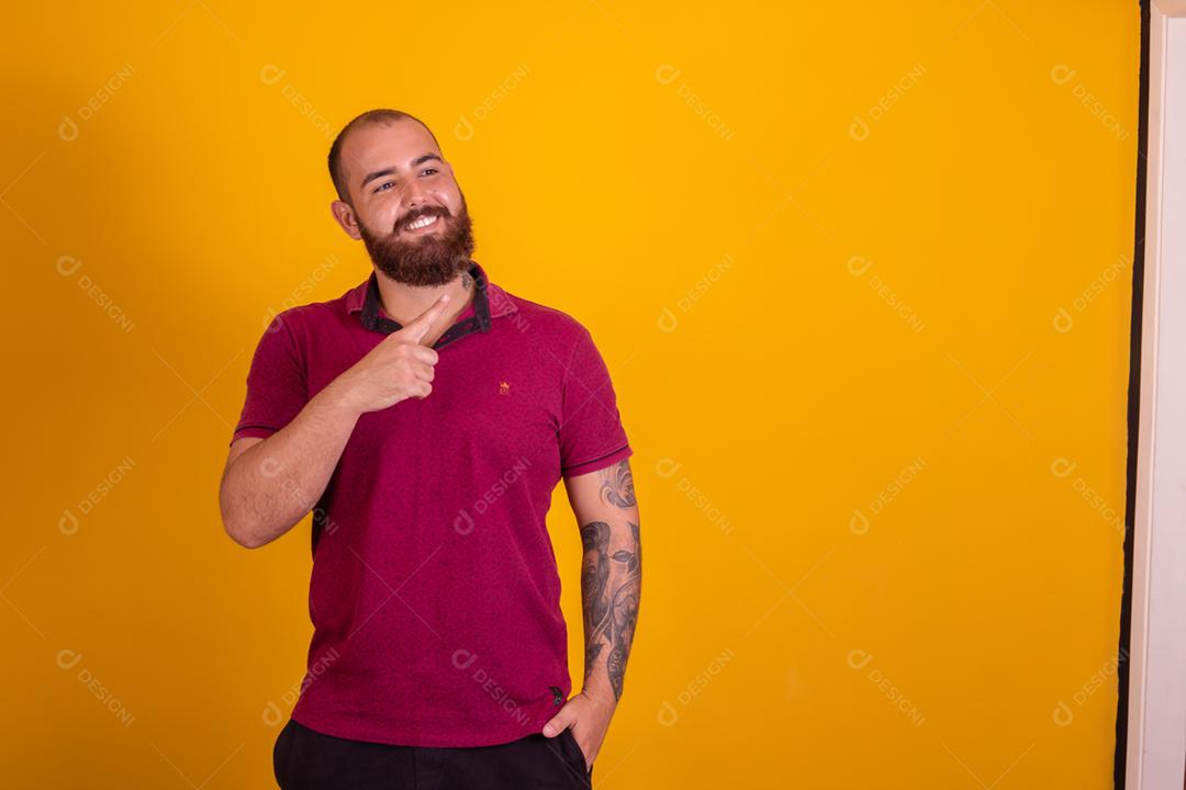 homem ruivo de barba usando uma camisera vermelha se barbeando