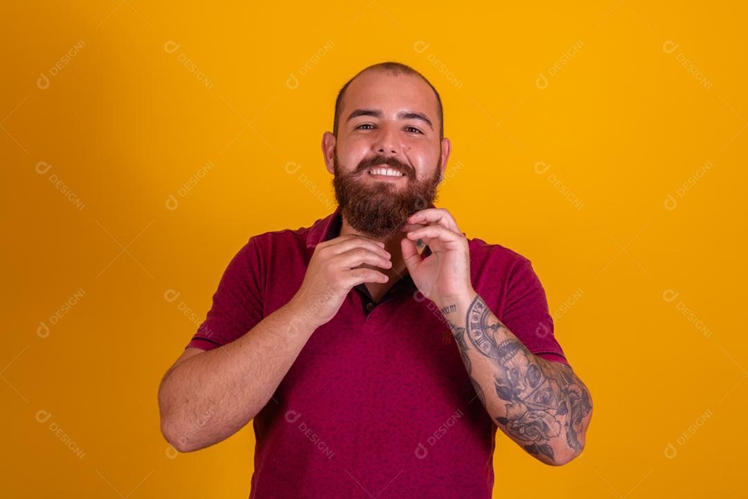 homem ruivo de barba usando uma camisera vermelha se barbeando