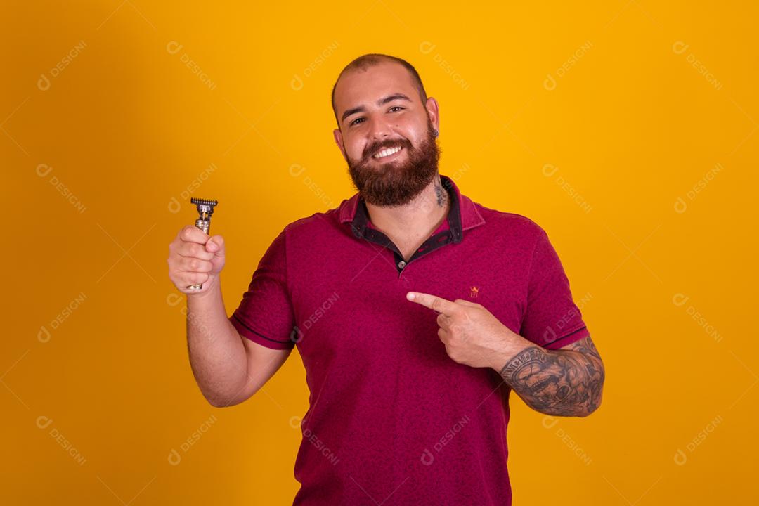 homem ruivo de barba usando uma camisera vermelha se barbeando