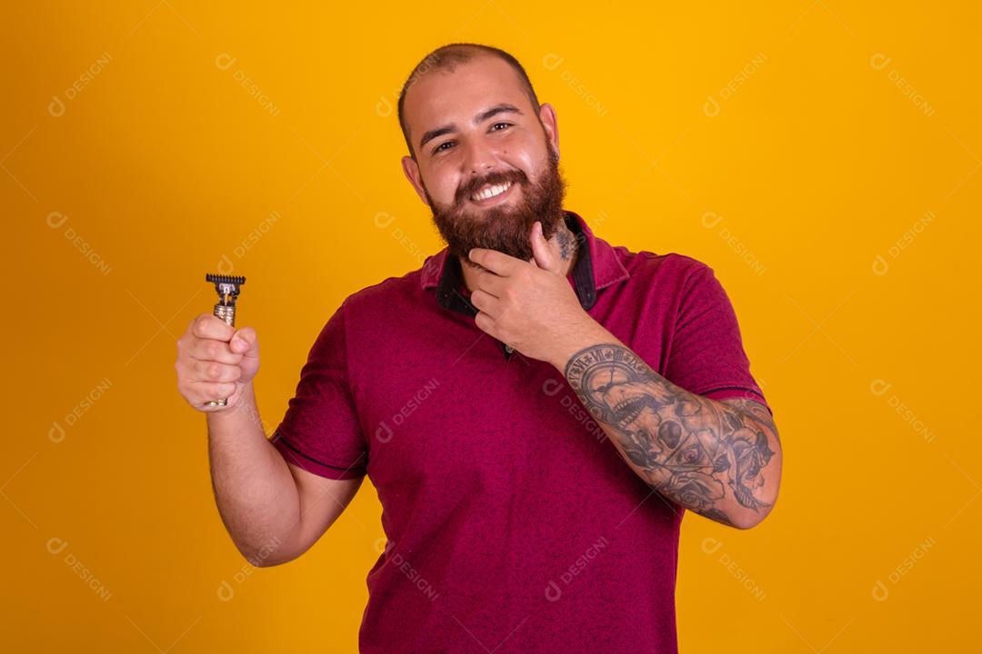 homem ruivo de barba usando uma camisera vermelha se barbeando