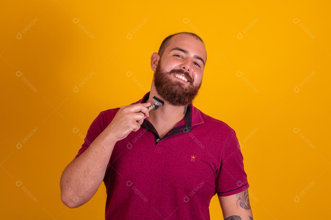 homem ruivo de barba usando uma camisera vermelha se barbeando