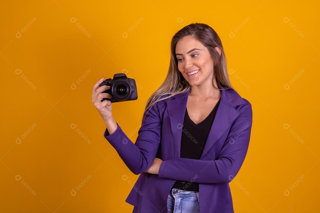 Mulher loira segurando uma camera fotografica