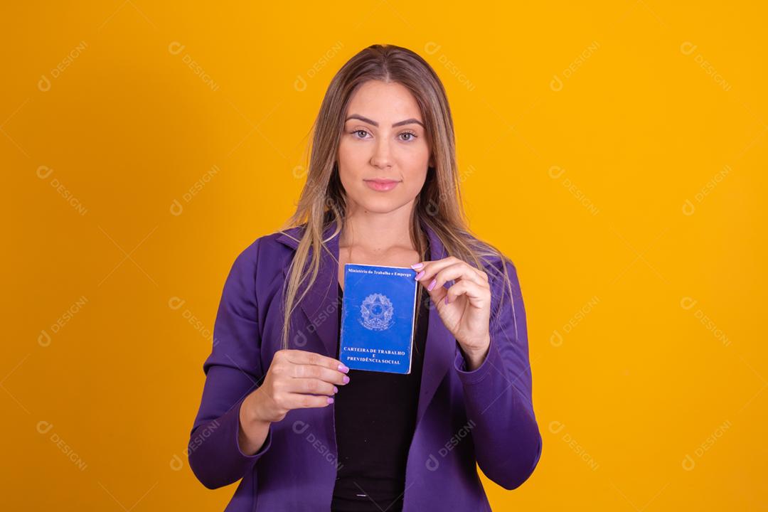 Mulher loira segurando uma carteira de trabalho da previdencia social