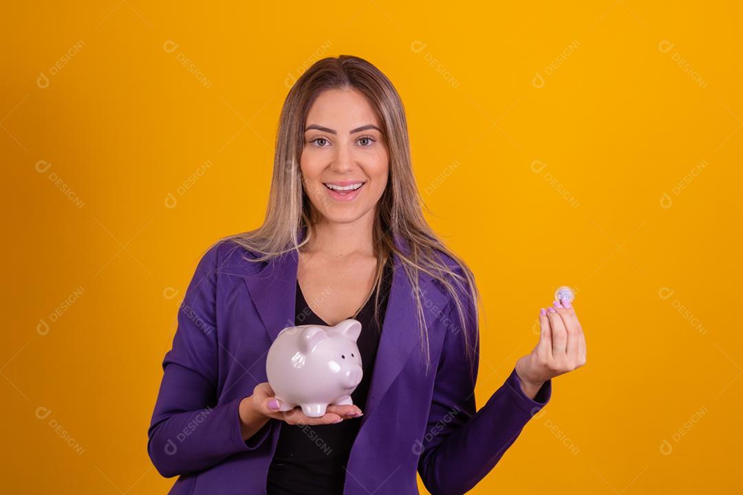Blonde woman putting coins into piggy bank to save