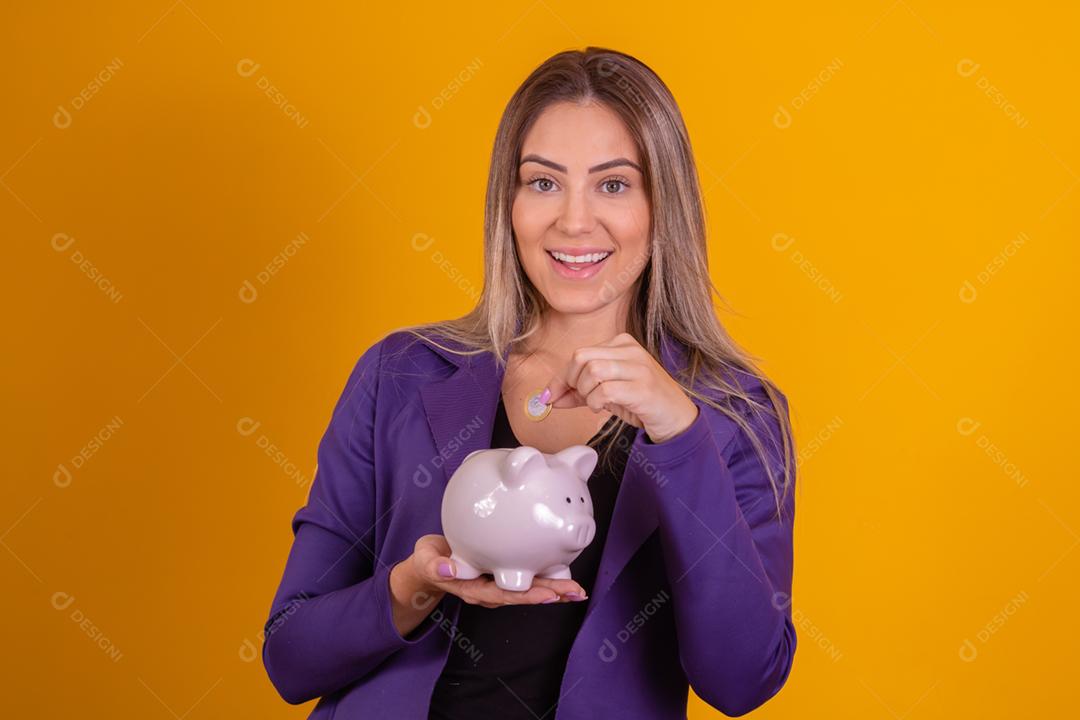 Mulher loira colocando moedas em porquinho para poupar
